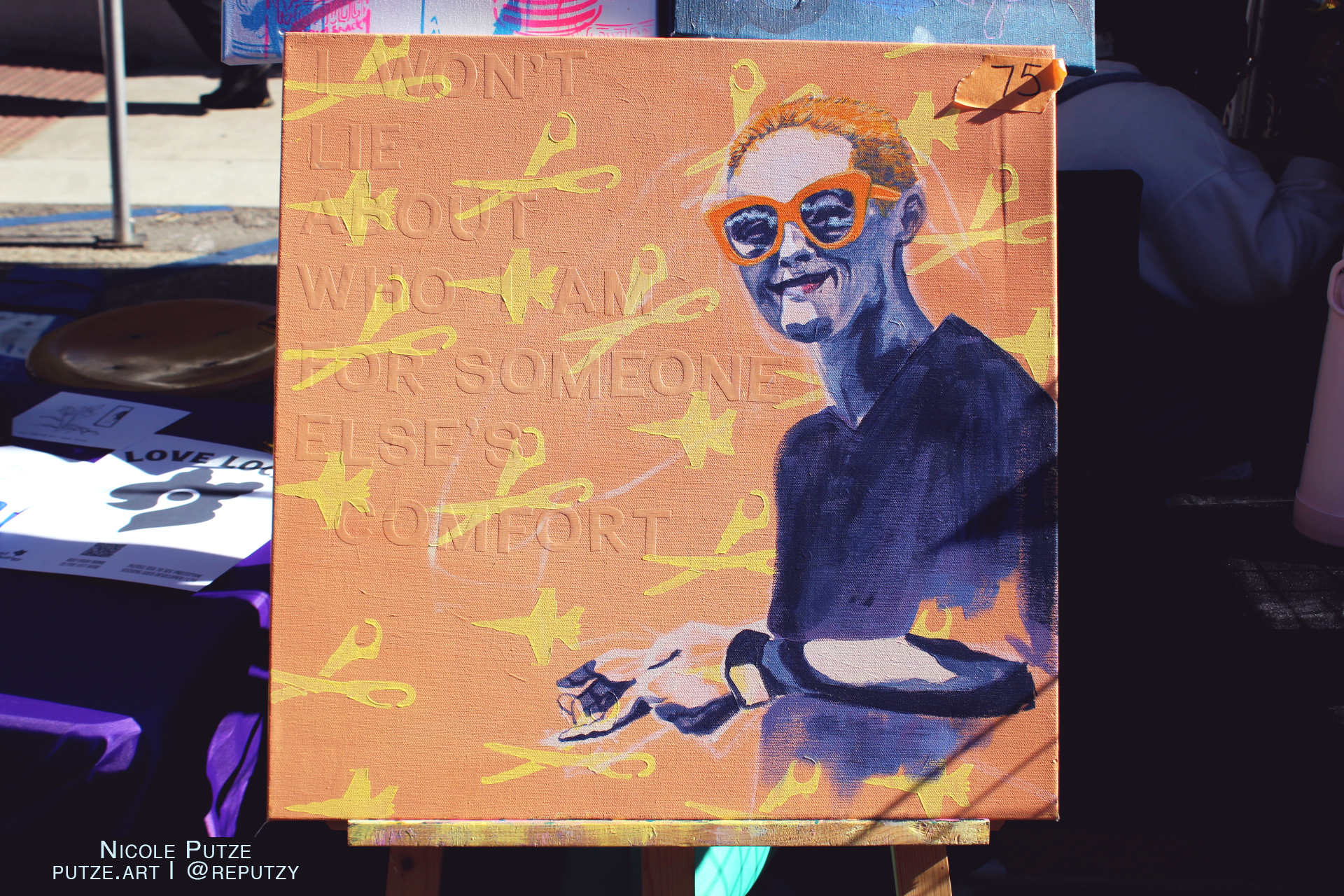 An orange canvas featuring a person with orange glasses and orange hair on with white skin. There is yellow scissors and air planes in a pattern over the orange. In the orange background there is lettering impressions saying:

I WON'T LIE ABOUT WHO I AM FOR SOMEONE ELSE'S COMFORT

Nicole Putze
Putze.art @Reputzy