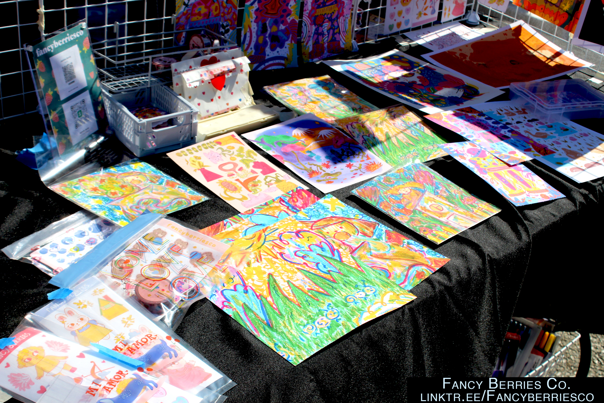 Crayon drawn style artwork and stickers on a black tablecover. 